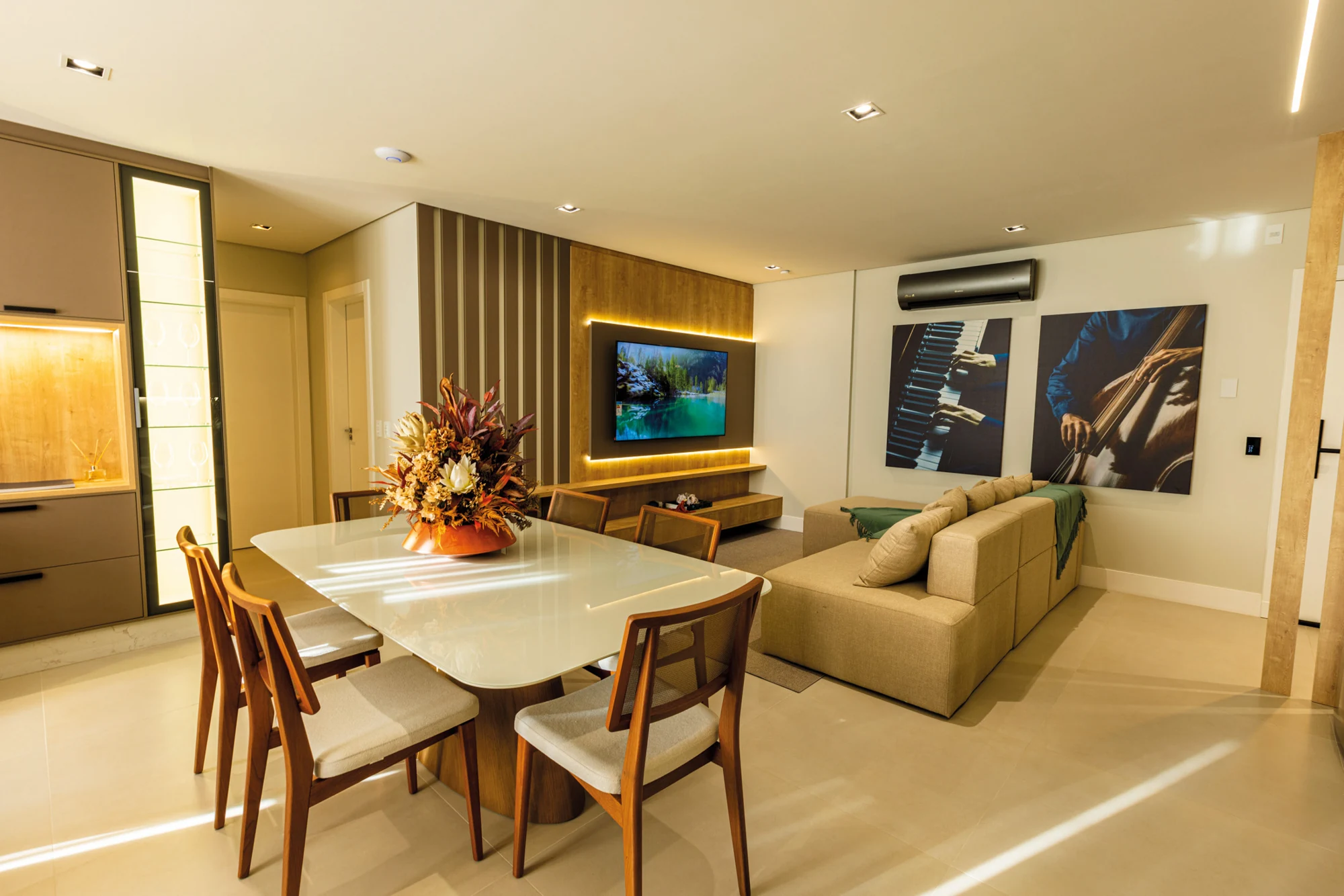 Estar e jantar do decorado 904 com mesa clara, cadeiras de madeira e sofá integrado ao ambiente